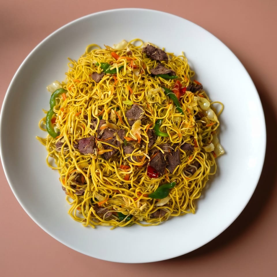 A white plate filled with yellow noodles, beef, and mixed vegetables.